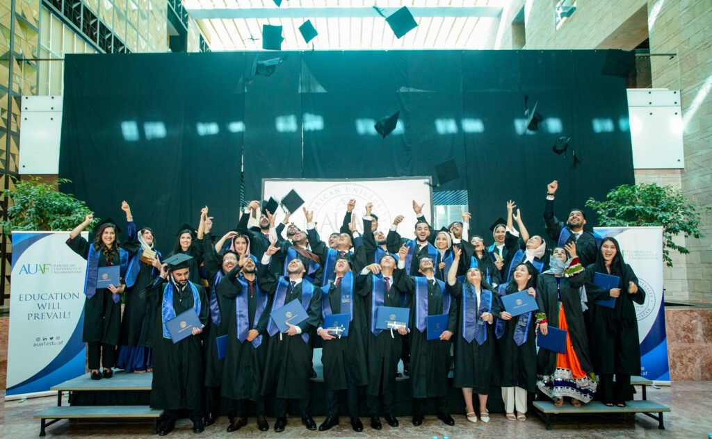 AUAF graduates throwing their caps.